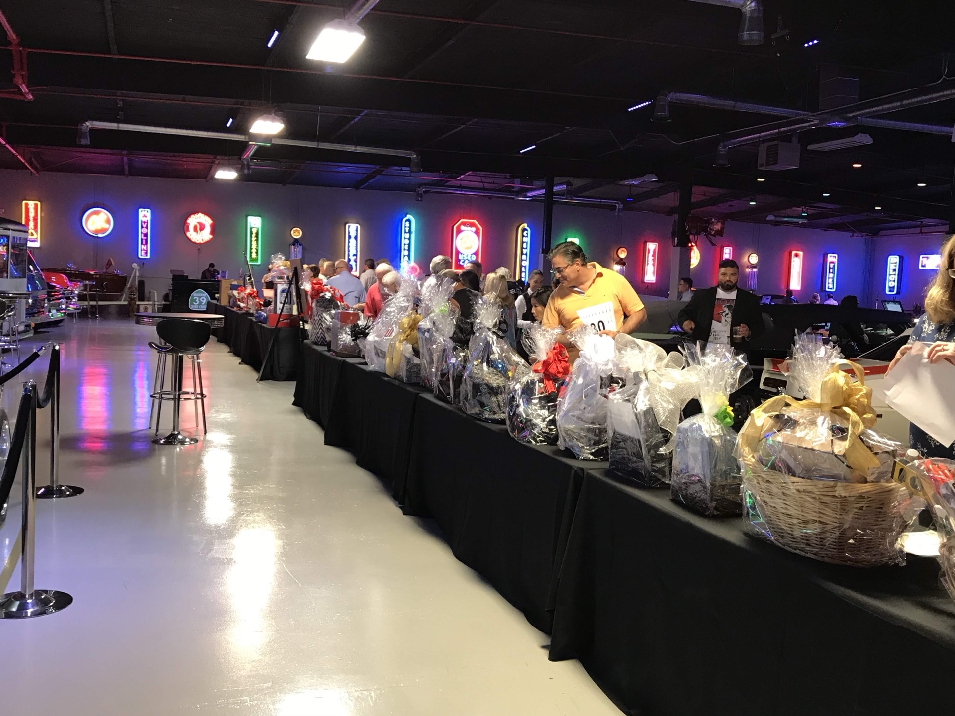 Charity gala silent auction setup with neon signs at Highway 39 Event Center in Anaheim